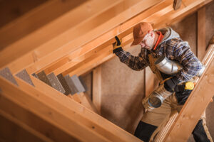Rat removal expert navigating attic beams to seal off rodent entry points.